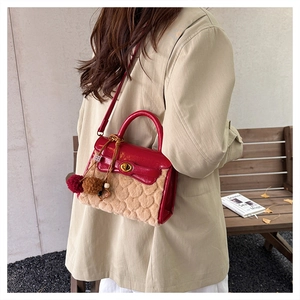 Close-up of red leather and beige faux fur crossbody bag with golden turn-lock