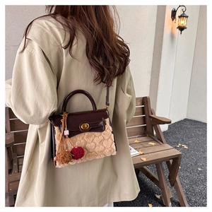 Outdoor view of a plush cream faux fur handbag with heart texture and leather top handle