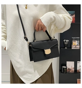 Détail de sac à main classique en cuir noir texturé avec boucle en métal doré élégante