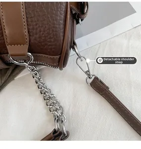 Detail of dark brown lychee grain leather with silver chain and removable shoulder strap