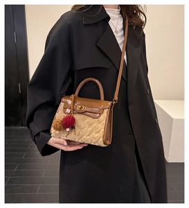 Detail of faux shearling and brown leather crossbody bag featuring gold twist lock and charm
