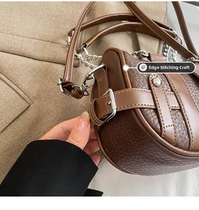 Detailed view of the piping craft and lychee grain leather on the brown handbag