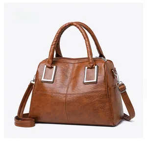 Micro side view of a brown leather handbag with silver metallic buckle details