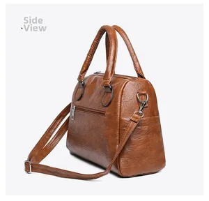 Brown faux leather Boston bag side view showing the rear hidden zipper pocket and soft texture
