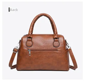 Detailed back view of brown soft leather tote bag showing a secure metal zipper pocket