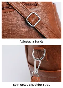 Detail of brown leather tote showing adjustable buckle and reinforced shoulder strap stitching