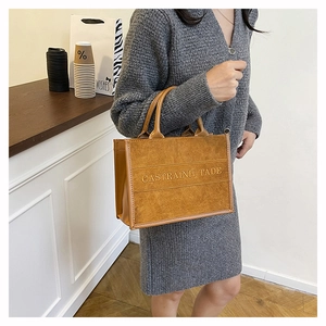 Brown frosted tote bag with CASTRAINH TADE embroidery and silk scarf handle detail