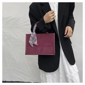 Detail of burgundy frosted tote bag with paisley silk scarf and embroidered lettering