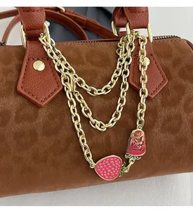 Detail of vintage leopard print Boston bag with gold chains and strawberry charms
