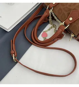 Detail of vintage leopard Boston bag with strawberry charm and metal chain strap