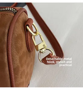 Close-up of golden detachable hardware hook and textured leather on boston bag