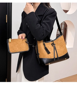 Detail of suede patchwork tote and clutch set showing premium texture and shoulder strap