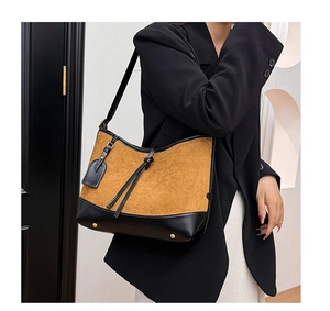 Detail of vintage suede patchwork tote bag with adjustable strap and protective base studs