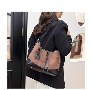 Detail of retro suede and leather tote bag featuring protective base metal rivets