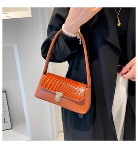 Brown faux crocodile leather baguette bag featuring a gold metal twist lock on the flap