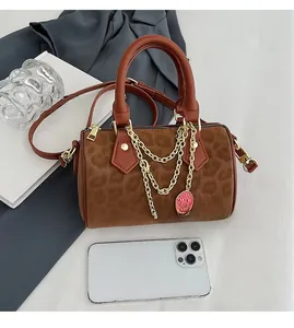 Detail of vintage leopard print Boston bag with gold chains and strawberry charm