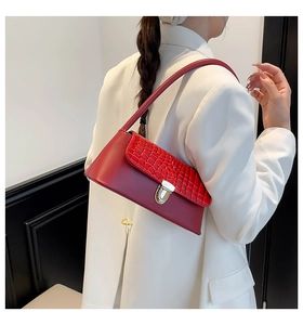 Detail of red crocodile pattern shoulder bag with a silver metal twist lock closure