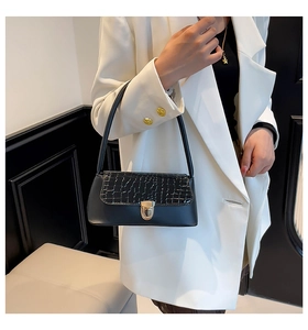 Detailed view of black crocodile pattern leather texture with elegant gold metal clasp