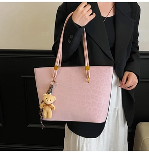 Detailed close-up of pink leopard print tote bag with gold metal buckle and bear charm