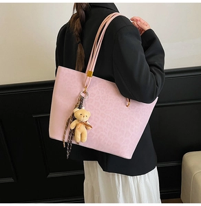 Pink leopard embossed tote bag with teddy bear charm and plaid scarf on model