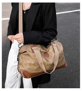 Brown canvas travel bag with leather accents shown on a model for short distance trip
