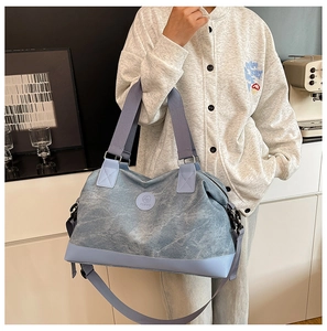 Detail of light blue travel bag with adjustable strap and Junyu logo in modern interior