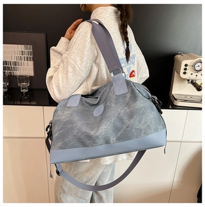 Detail of light blue travel bag showing reinforced leather base and durable canvas texture