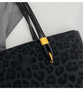 Close-up of premium leopard print tote bag with gold-tone hardware and suede texture