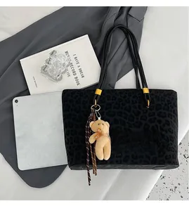 Top view of leopard print tote bag capacity showing iPad and books for size comparison