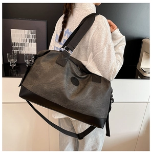 Detailed view of the large grey travel bag with leather reinforcement and durable strap
