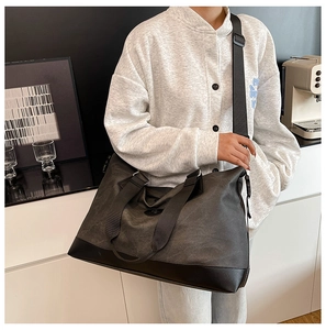 Detailed side view of large canvas travel bag with leather accents for business trips