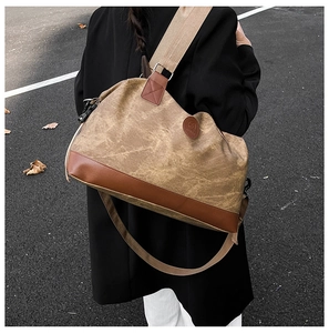 Detailed view of the vintage khaki canvas travel bag with premium brown leather bottom