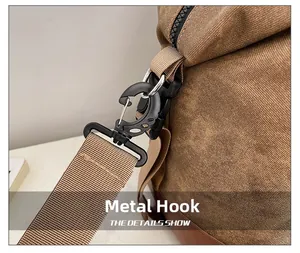 Detailed close-up of a durable metal hook and nylon strap on a vintage canvas travel bag