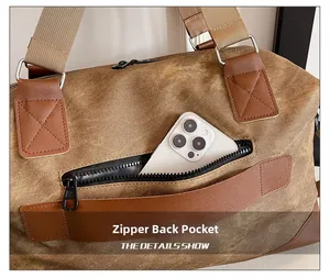 Detail of the rear zipper pocket on canvas travel bag holding a smartphone for scale