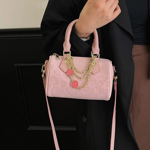 Pink leopard print Boston bag with gold chain and strawberry charms held by model
