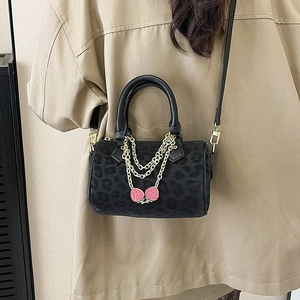 Leopard print Boston bag with gold chains and strawberry pendants on a shoulder strap