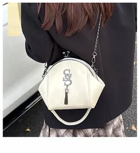 Détail du sac chaîne en cuir beige avec logo SS en métal et élégante frange à glands