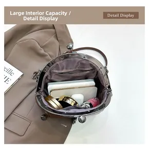 Vue de dessus de l'intérieur du sac besace montrant la poche zippée et les accessoires