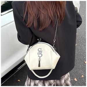 Photo extérieure du sac coquille crème avec cadre métallique et pompon argenté