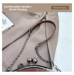 Détail du sac à fermoir kiss-lock en cuir marron avec chaîne argentée et cadre métal
