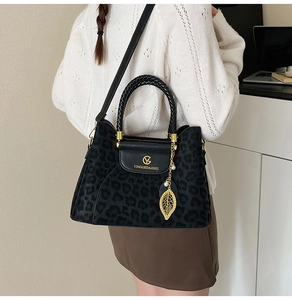 Détail du sac seau léopard avec pendentif perle feuille dorée et poignée tressée