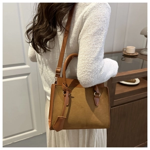 Detail shot of vintage caramel tote bag featuring matte patchwork and round handles