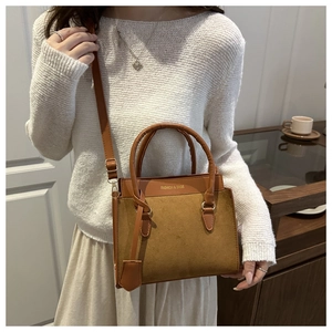 Detail of a brown leather shoulder bag with FASHION & BAGS print and dual handles
