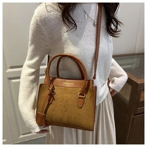 Detail of vintage brown tote bag with matte texture and contrast leather stitching