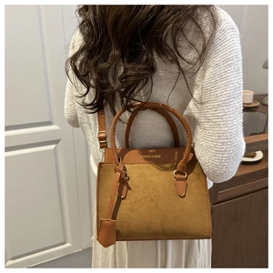 Brown leather crossbody bag with top handle and Fashion & Bags text on neutral background