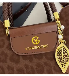 Détail du sac à main léopard avec pendentif feuille dorée et logo de marque