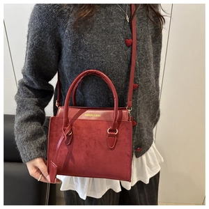 Close-up of burgundy tote bag showing matte suede and smooth leather texture mix