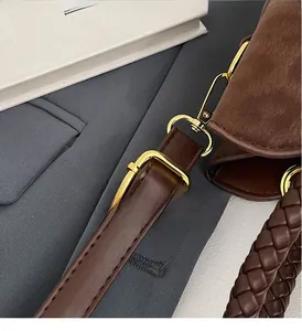 Détail du sac seau léopard avec boucle dorée et poignée en cuir tressé raffiné