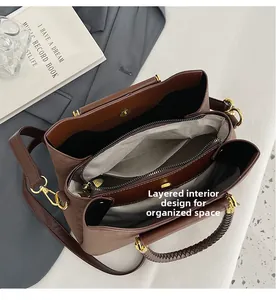Vue intérieure du sac seau marron montrant trois compartiments spacieux et zips dorés
