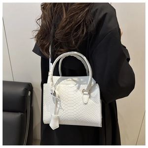 Detail of white crocodile pattern tote with FASHION & BAGS gold lettering